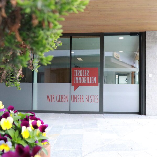 Fensterfront Standort Wiesing mit Logo Tiroler Immobilien | © EVITA Marketing